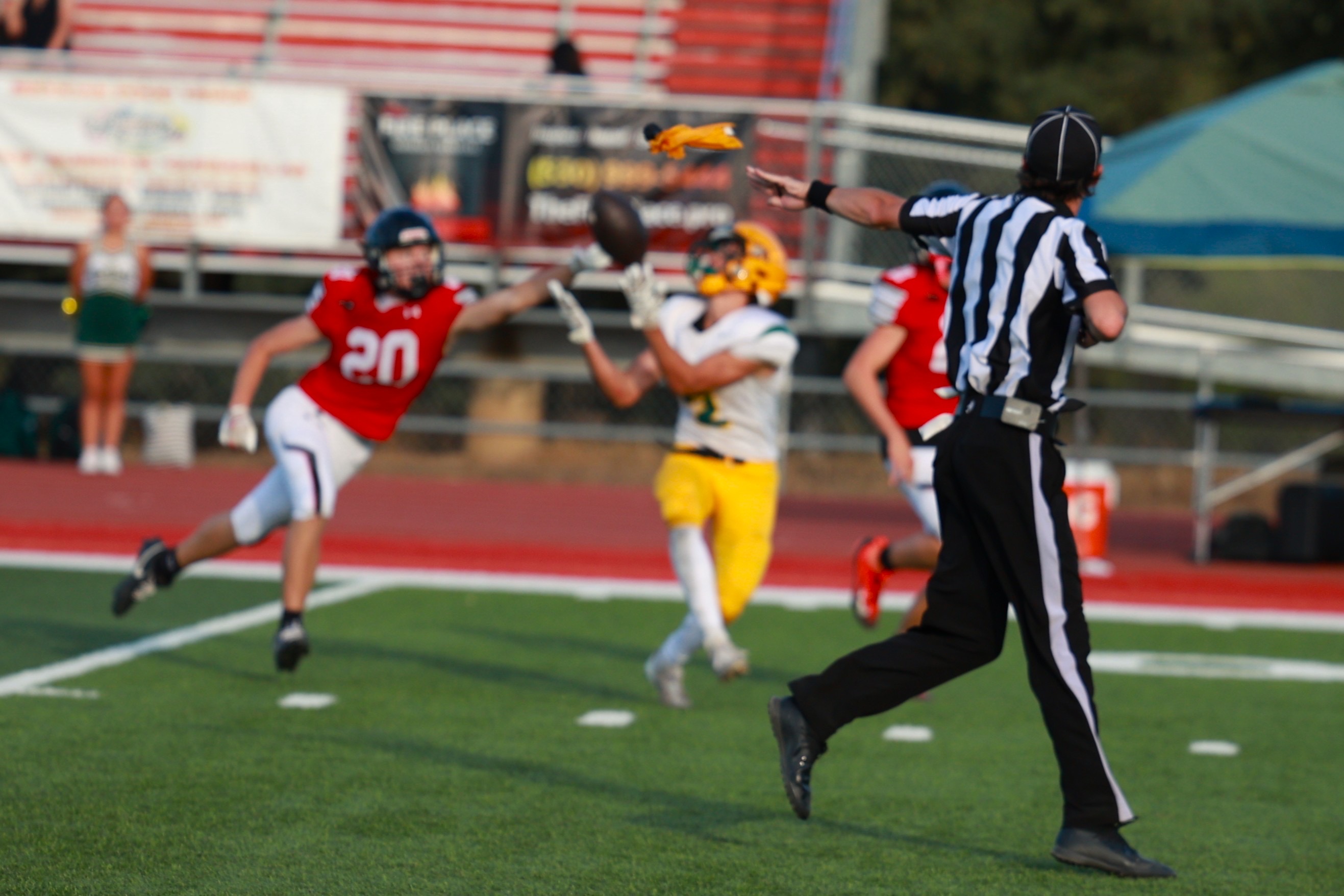 Football official throwing a penalty flag during a play